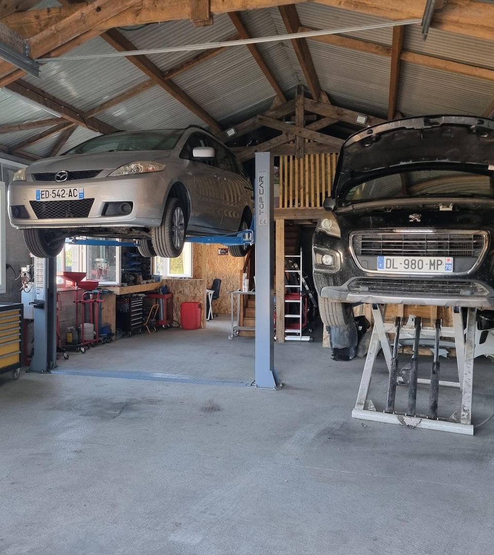 Deux véhicules en réparation sur des ponts élévateurs 