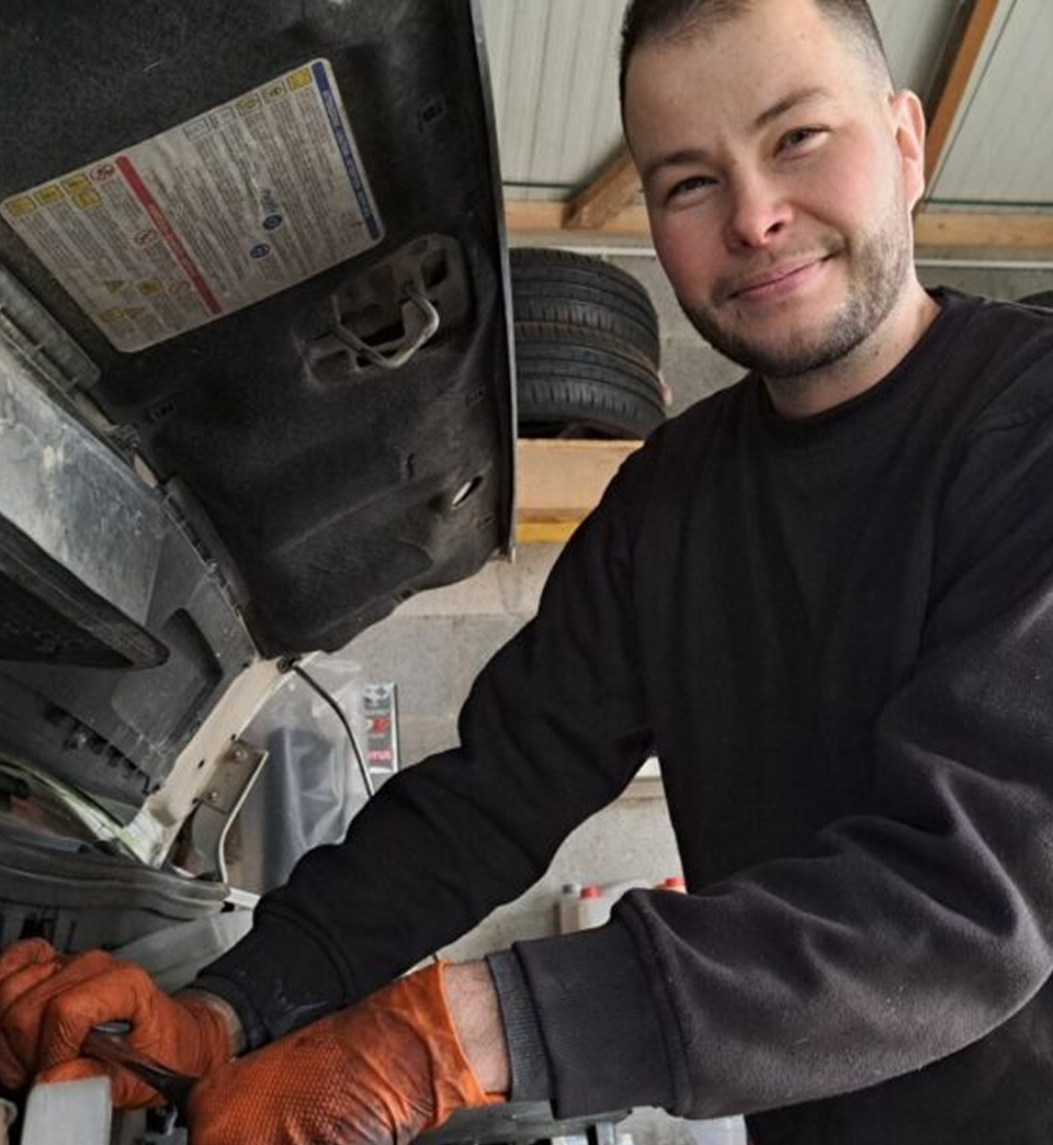 Kyllian Couvé travaillant sur le moteur d'une voiture